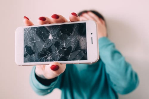 Girl Holding Broken Cell Phone with red fingernails